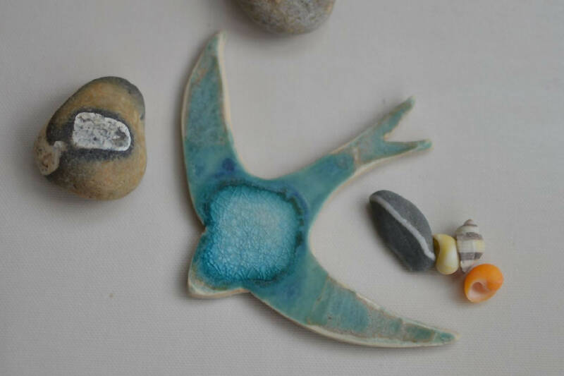 Ceramic Swift glazed in blues and turquoise designed to hang on the wall
